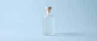Clear glass bottle with cork stopper on light blue background, isolated for cosmetics, skincare, perfume, or beverage packaging design.