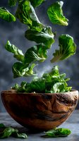 Fresh green lettuce leaves floating above wooden bowl against dark background, dynamic food composition with water drops and dramatic lighting.
