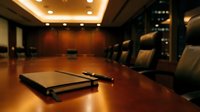 Wooden conference table with notebook and pen in modern boardroom with leather chairs and warm lighting for business meetings.