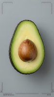 Fresh avocado half with pit on neutral background showing creamy green flesh texture for healthy cooking and nutrition content.