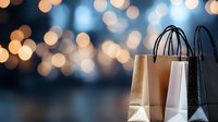 Shopping bags in gold, white and black colors against blurred bokeh lights background creating festive holiday atmosphere for retail and commerce designs.