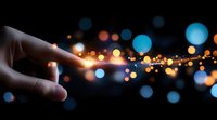 Finger touching glowing light spark with magical bokeh effect in dark background, creating ethereal atmosphere. Concept of connection and spiritual energy.