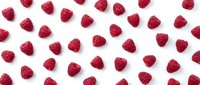Fresh raspberries scattered on white background, isolated berries ready for food, nutrition, and culinary design projects.