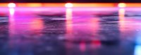 Vibrant pink and purple spotlights reflecting on glossy wet surface creating dramatic atmospheric lighting effect with bokeh blur. Perfect for nightclub or stage backgrounds.