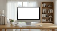 Modern home office workspace with blank computer monitor on wooden desk ready for mockup presentations and digital content display in bright interior.