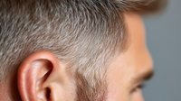 Close-up profile view of mature Caucasian man with gray hair and ear against neutral background, showing natural aging process and distinguished appearance.