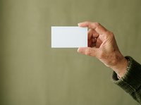Male hand holding blank white business card against olive green background for branding and corporate identity design projects.