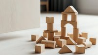 Natural wooden building blocks scattered on floor creating educational play scene for children development and learning activities.