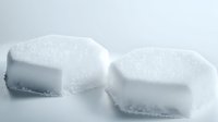 Two white sugar cubes on light background with soft shadows, minimalist composition showing sweetness and purity in modern food photography style.