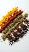Colorful spice powder arrangement with turmeric, paprika, herbs, star anise and peppercorns on white background for culinary and cooking projects.