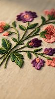 Colorful floral embroidery with purple and pink flowers on natural fabric showcasing traditional needlework craftsmanship and textile art techniques.
