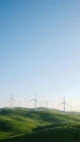 Wind turbines dotting rolling green hills under clear blue sky, representing renewable energy and sustainable power generation for environmental and industrial projects.