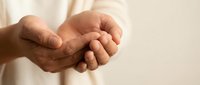 Cupped hands in protective gesture showing care and support, open palms ready to receive or give, gentle human touch concept for healthcare and compassion themes.