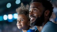 Young African American father and child watching entertainment event together, sharing joyful moment with bright bokeh lights in background, expressing genuine happiness.