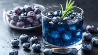 Fresh blueberry cocktail garnished with rosemary sprig in glass, ice cubes and scattered berries on dark background, refreshing summer drink.