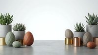 Modern minimalist home decor with succulents in concrete planters and geometric objects on marble surface for interior design projects.