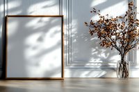 Empty wooden frame mockup with autumn dried branches in glass vase against white wall with natural window shadow overlay. Modern minimal interior design.