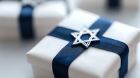 White gift box wrapped with navy blue ribbon and decorated with silver Star of David pendant, perfect for Hanukkah celebration or Jewish holiday occasion.