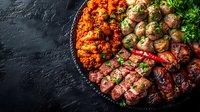 Assorted grilled meat and vegetable skewers arranged on dark slate plate with fresh herbs and spices for catering, restaurant menu, food photography, and culinary content.