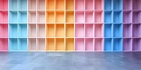 Colorful empty storage compartments on wall with pastel pink, blue, yellow and purple sections creating geometric pattern against concrete floor. Modern interior design.
