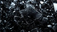 Dramatic close-up of shattered black glass fragments scattered in dark lighting with sharp edges and reflective surfaces creating abstract artistic composition.