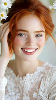 Young redhead woman with freckles smiling while holding white daisies in hair wearing lace top for natural beauty and skincare concepts.
