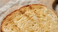 Sliced whole wheat bread with visible air pockets and golden-brown crust, suitable for food photography, bakery marketing, and culinary content.