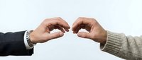 Two hands reaching toward each other in connection gesture, symbolizing partnership, teamwork and collaboration in business relationships.