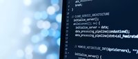 Close-up of programming code on computer screen showing software development work. Dark blue interface with white text displaying functions and commands.