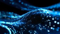 Glowing blue particles forming dynamic wave patterns against dark background, abstract digital network visualization with bokeh light effects.