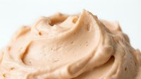 Creamy peanut butter frosting with swirled texture, isolated on white background, ready for bakery, dessert, and food styling projects.
