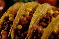 Mexican style crispy corn tortilla tacos filled with seasoned ground beef, fresh diced tomatoes, yellow corn kernels and melted cheese, close up food photography.