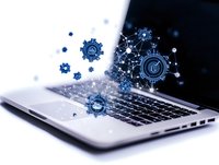 Digital transformation concept with glowing blue gears and network connections floating above laptop keyboard, representing technological innovation and automation.