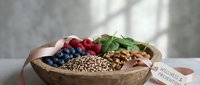 Wooden bowl filled with fresh berries, nuts, and seeds arranged for healthy eating and wellness content, nutrition marketing, and diet promotion.
