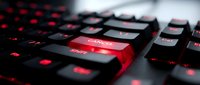 Gaming keyboard with red LED backlight and illuminated keys for computer setup and esports enthusiasts.