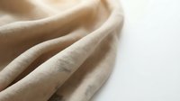Soft beige linen fabric with natural texture and gentle folds creating elegant drapery for home decor and fashion design projects.