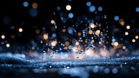Magical glowing bokeh lights and water drops on dark background create dreamy atmosphere with blue and golden sparkles in night scene.