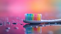 Colorful toothbrush with rainbow bristles reflected on wet surface against pink and blue bokeh background, dental hygiene concept for healthy lifestyle.