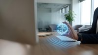 Businesswoman holding holographic globe with copyright symbol in modern office workspace, representing intellectual property protection and global digital business solutions.