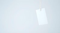 White blank price tag hanging on string against light gray background with copy space for retail and shopping concepts.