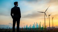 Businessman silhouette overlooking renewable energy wind turbines and modern city skyline at sunset, representing sustainable development and green future.