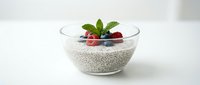 Chia seed pudding with fresh berries and mint in glass bowl on white background for healthy breakfast dessert recipes and superfood nutrition content.