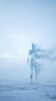 Young woman with fair skin standing on a beach, her body dissolving into ethereal mist and smoke, creating a dreamlike double exposure effect. Cool blue tones throughout. Suitable for conceptual, spiritual, and editorial design projects.