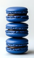 Stack of three blue macarons with chocolate filling on white background, French pastry dessert for bakery menu design and culinary projects.