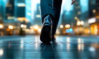Close-up view of walking feet in sneakers on wet reflective surface at night with blurred city lights and bokeh in background, moody urban atmosphere.