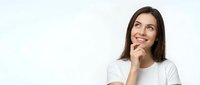 Young brunette woman in white t-shirt smiling and looking up thoughtfully with hand on chin, isolated on white background for design projects.