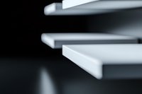 Minimalist abstract composition of white geometric shapes casting soft shadows on dark background, creating depth and perspective for modern design projects.
