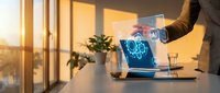 Professional using laptop with holographic brain display in modern office during golden hour sunset for technology and artificial intelligence concepts.