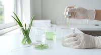 Scientist in white gloves conducting plant extract research with green liquid samples and aloe vera leaves in modern laboratory setting for botanical studies.