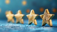 Golden wooden stars arranged in row on blue textured background with selective focus, creating festive holiday atmosphere for seasonal decorations.